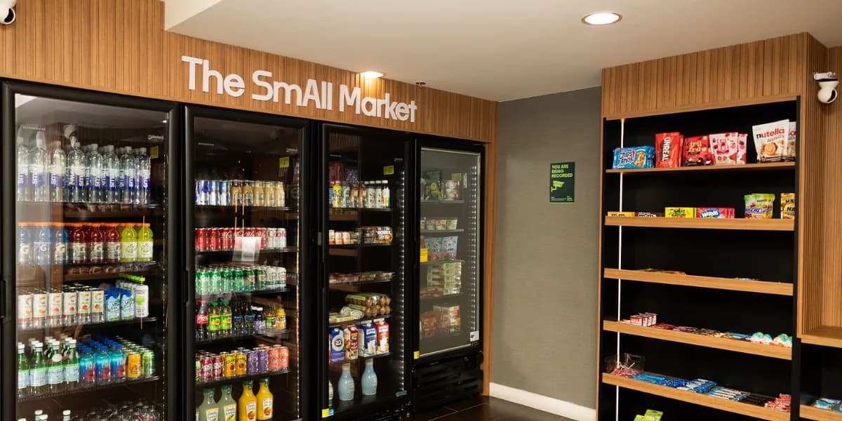 Coolers with water, sodas and juices next to snack shelves at The SmAll Market