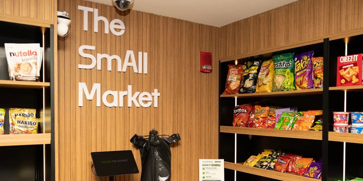 Self-checkout kiosk and snack shelves at The SmAll Market, open 24/7 for residents only
